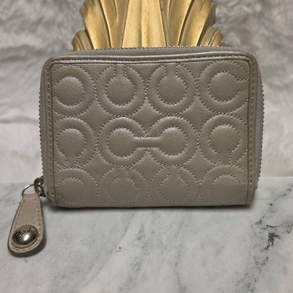 Coach zip-around wallet  an embossed signature "C" quilted pattern. Metallic gre